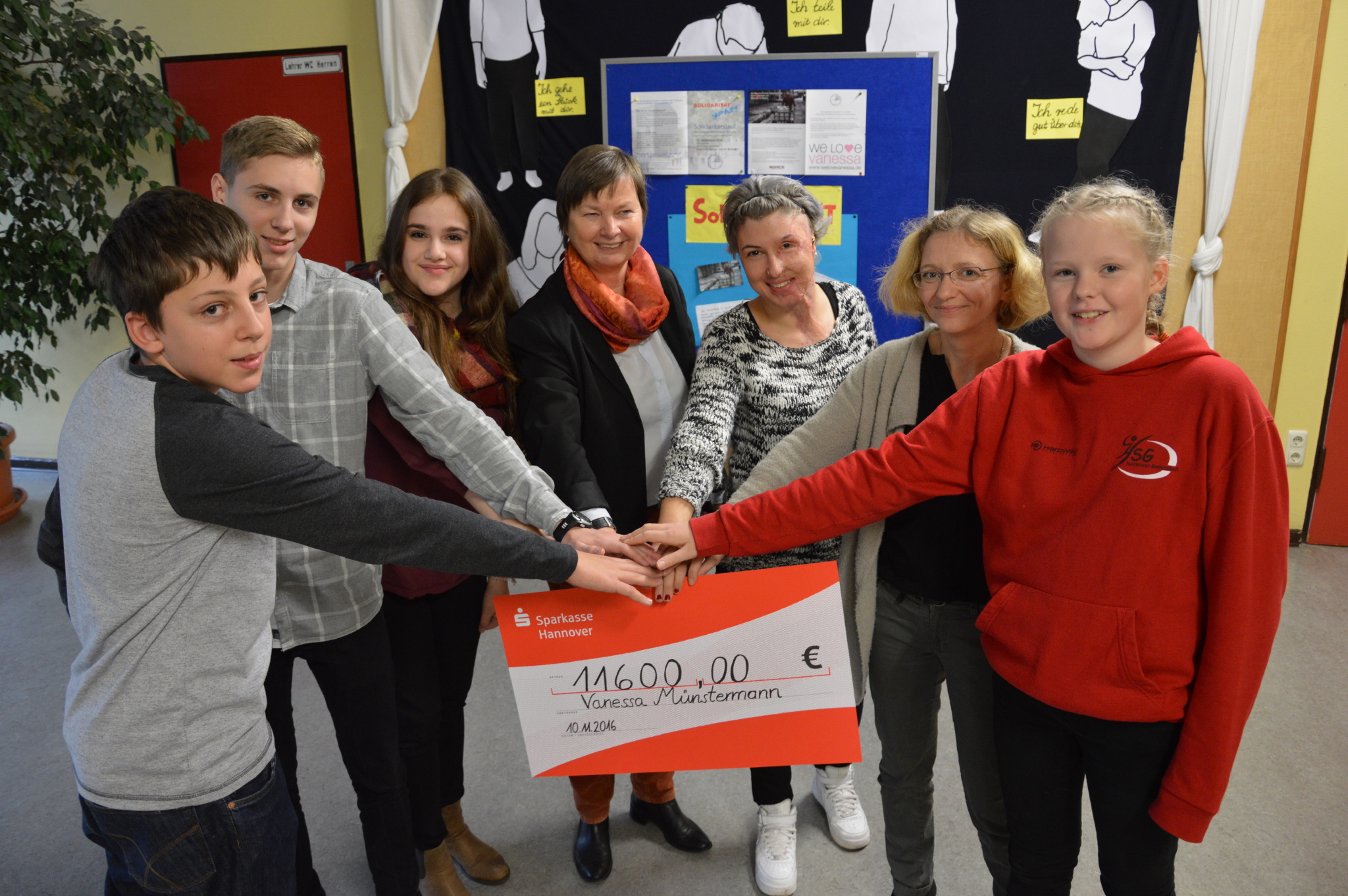 11.600 Euro haben die Schüler der Ludwig- Windthorst- Schule für Vanessa gesammelt. Schulleiterin Gabriele Herzberg (l. v. Vanessa) und Lehrerin Katja Nolte (r. v. Vanessa) haben gemeinsam mit Schülern einen großen Check vorbereitet. Pia Ziesenesz und Sean Frohne (vorne rechts und links) haben mitgesammelt. (Bild: © pkh)